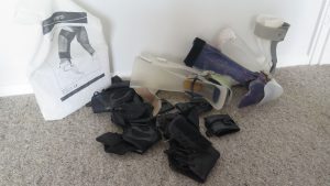 About 8 plastic ankle foot orthotics lying in a pile